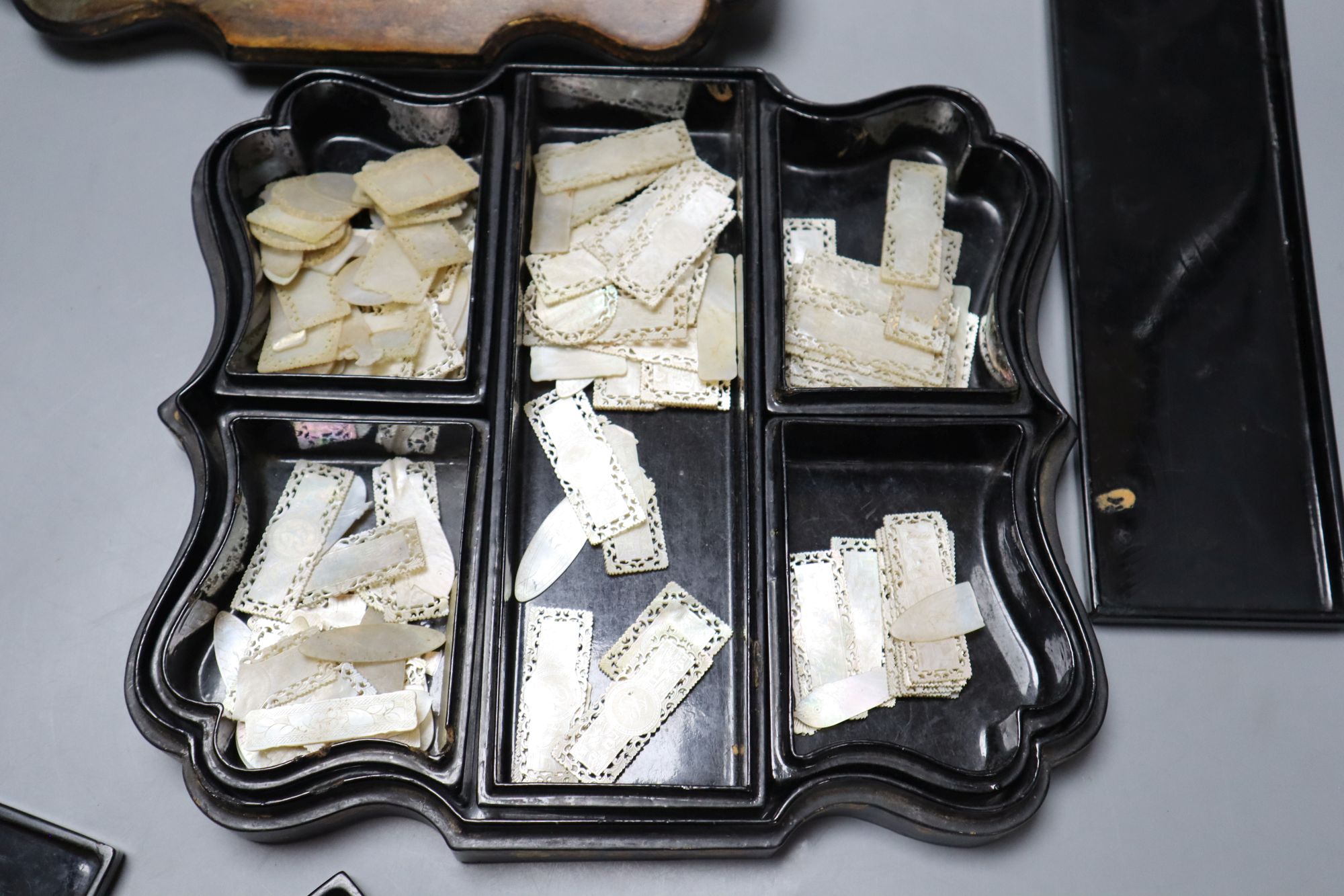 A Jennens and Bettridge papier mache box games box containing a quantity of Chinese mother of pearl counters, length 30cm